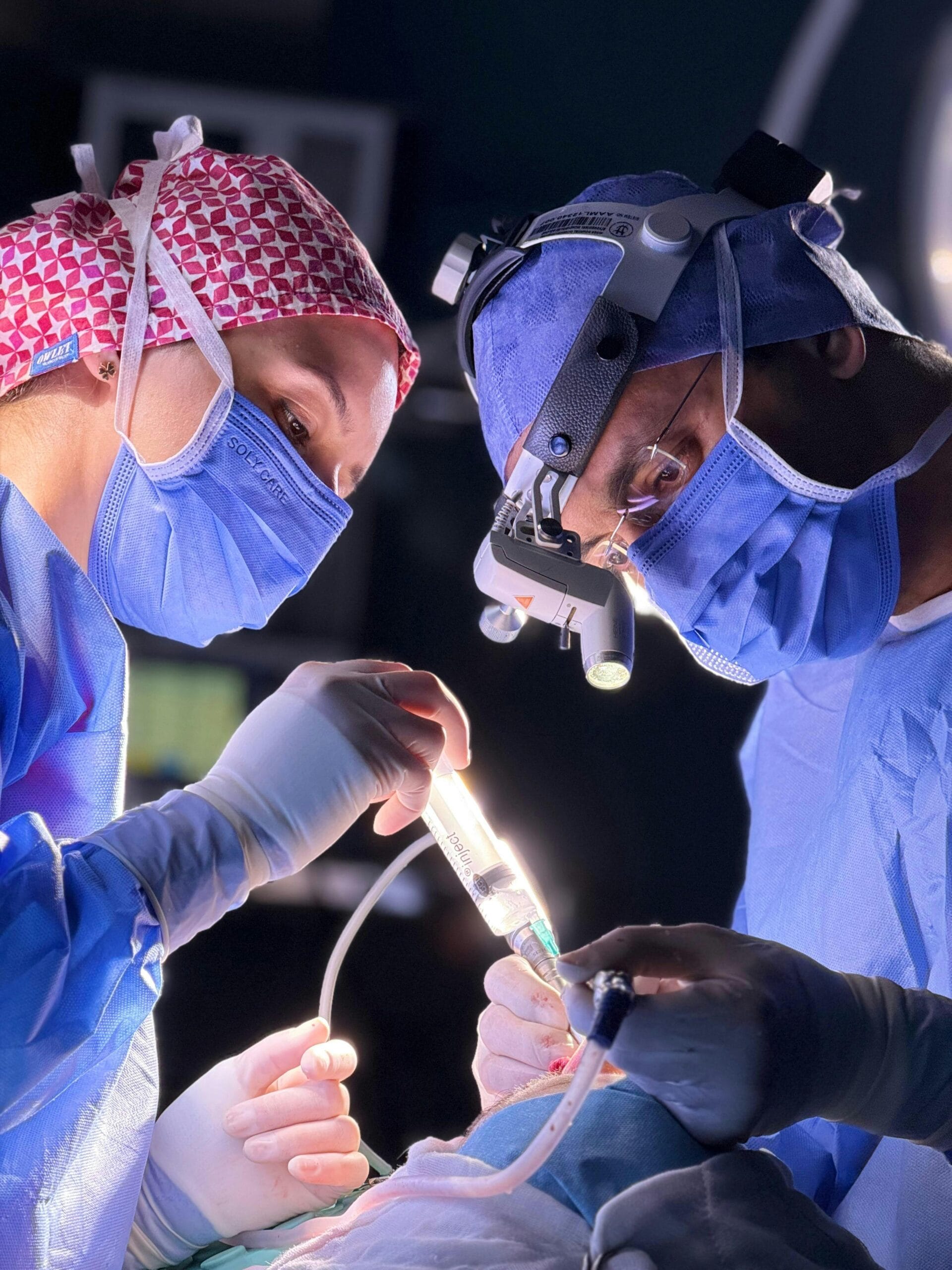 Two surgeons focused during a complex surgery in a well-equipped operating room.